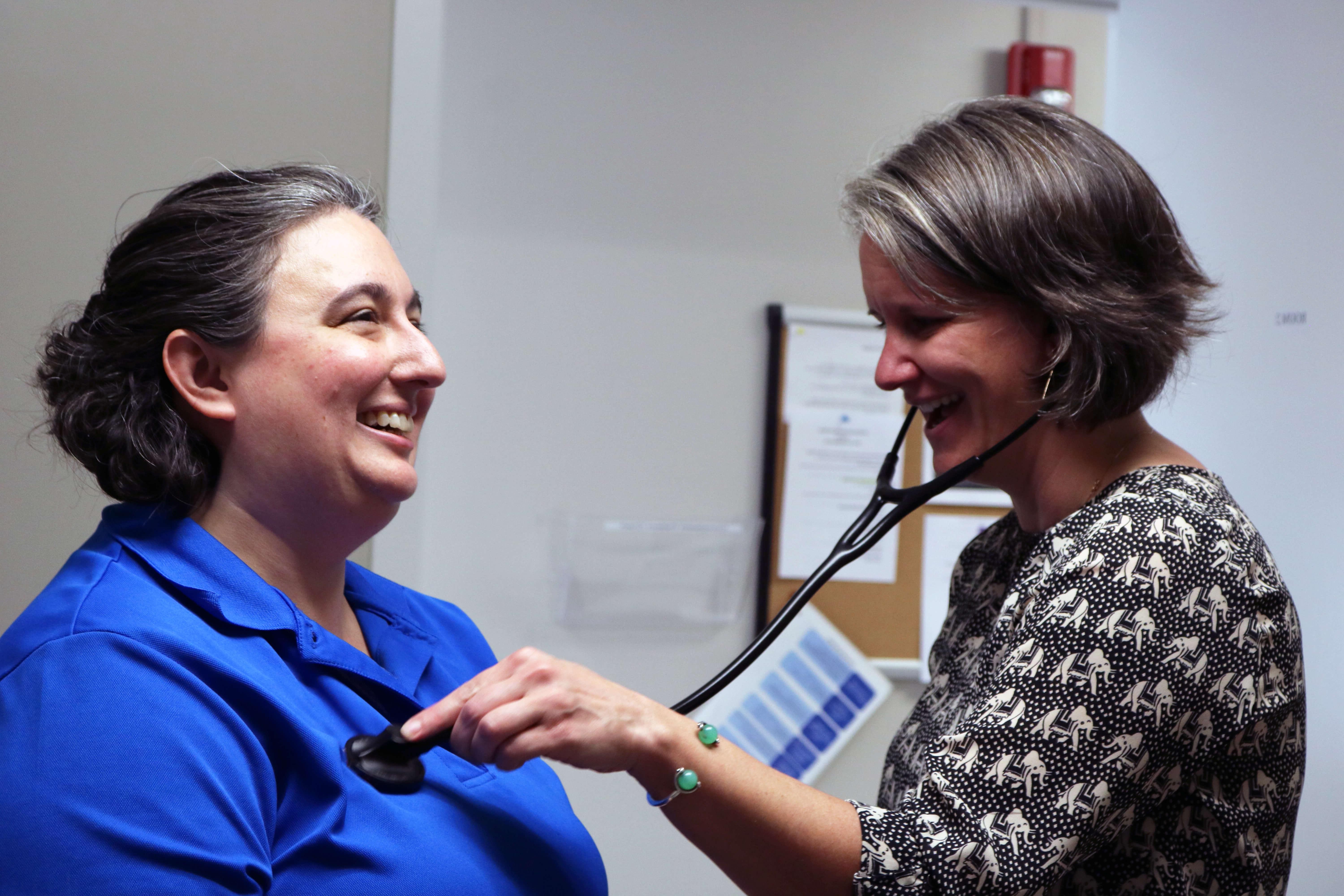 physician listening to a patient's heart with a stethoscope